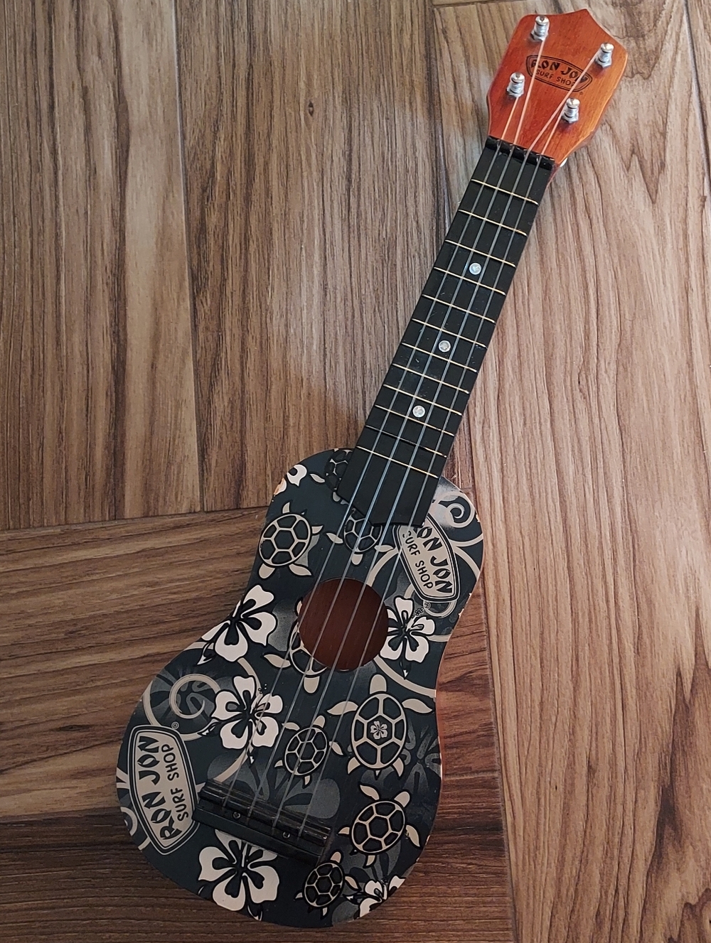 Ron Jon Black Floral Turtle Pattern Ukulele with Orange Headstock 21".